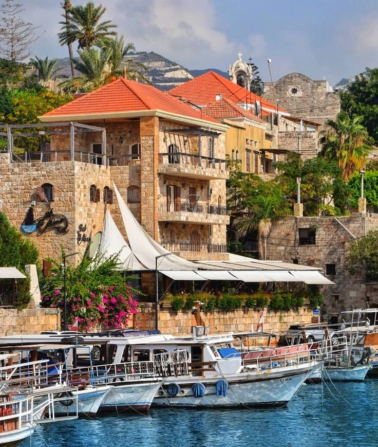Byblos old harbor with stone buildings, cobblestone alleys, and fishing boats at sunset on the Mediterranean